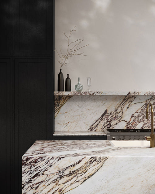 Marble countertop with dark brown and beige patterns, black cabinets, and decorative vases.
